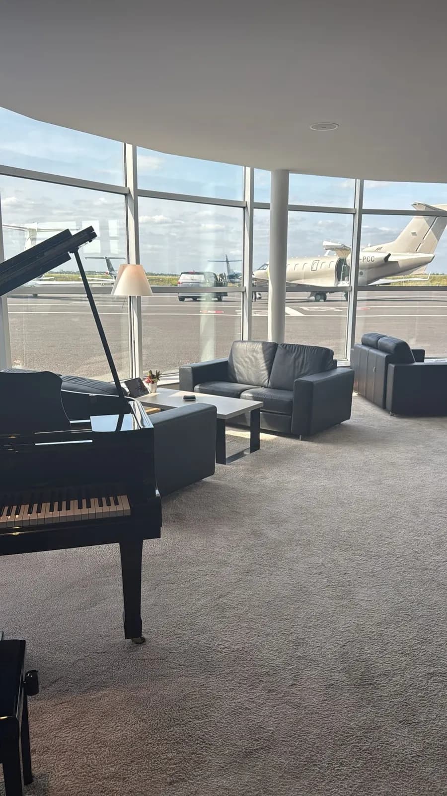 Private terminal lounge with a piano, a jet on the apron