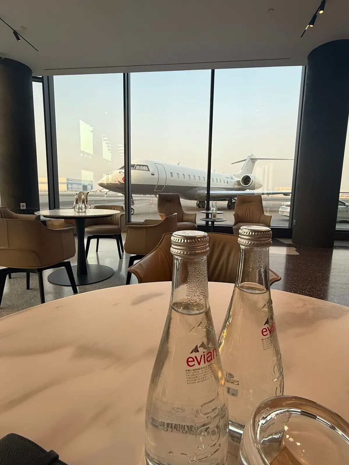 Lounge table, a jet parked beyond the windows