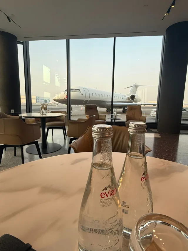 Lounge table, a jet parked beyond the windows